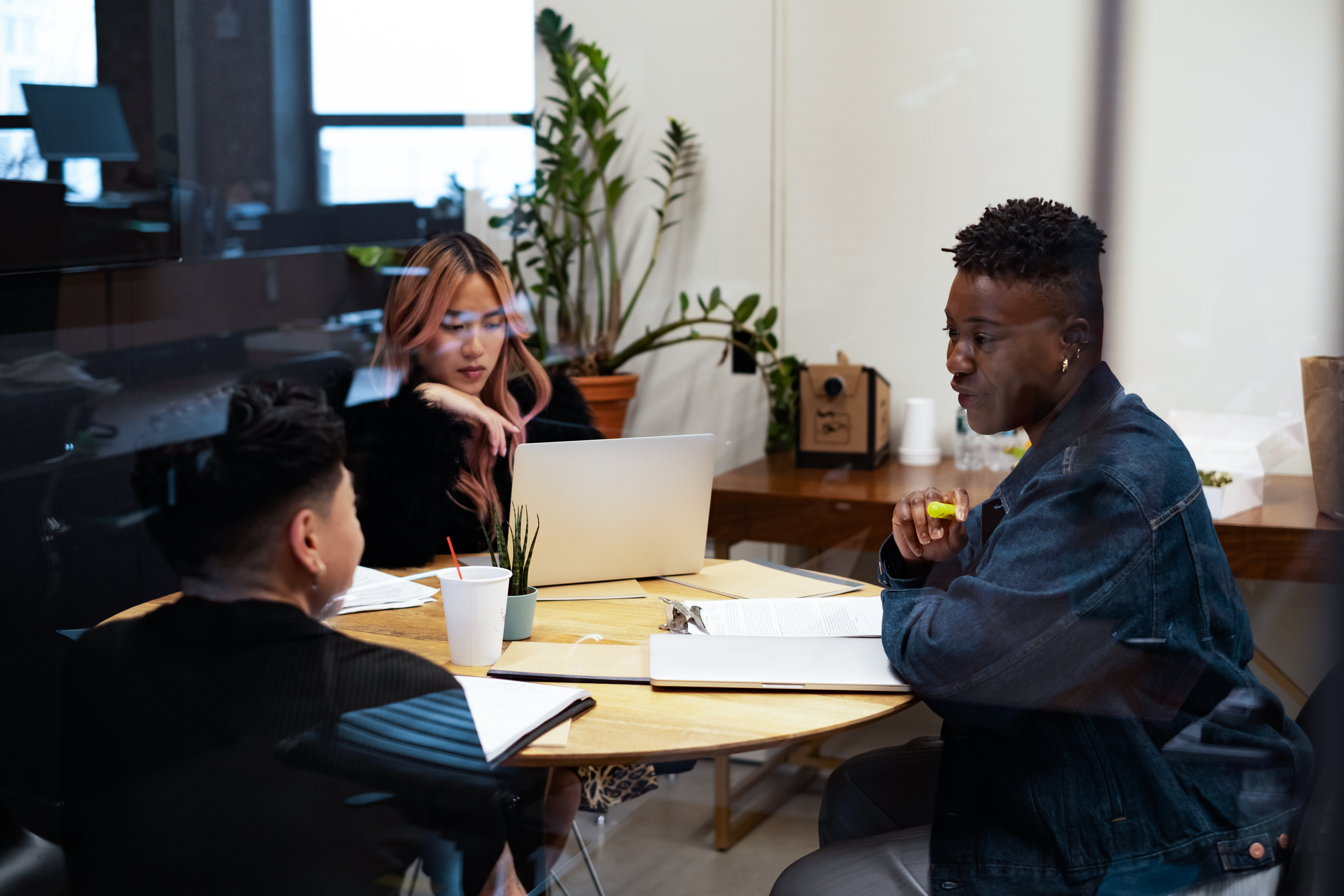A group of co-workers of varying genders having a meeting photograph of a library